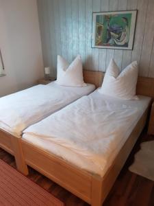 dwa łóżka siedzące obok siebie w pokoju w obiekcie Isoldes Ferienparadies w mieście Heiligkreuzsteinach