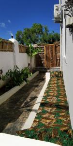 a walkway in front of a house with a fence at Peanut and Butter Guesthouse and Bistro in Nungwi