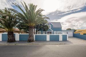 a house with two palm trees in front of it at House w Pool, Fireplace, Braai in Cape Town