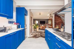 una cucina con armadi blu e un soggiorno di House w Pool, Fireplace, Braai a Città del Capo