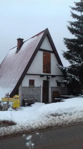 een klein wit huis met een dak in de sneeuw bij Vikend Kuca Milica in Kopaonik