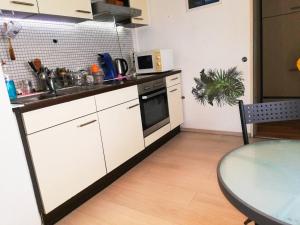 - une cuisine avec des placards blancs, une table et un évier dans l'établissement Vacation Apartment Near The Black Forest, à Villingen-Schwenningen