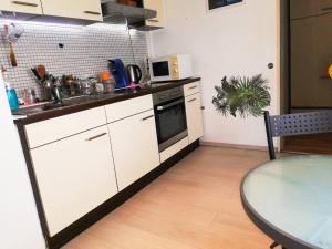 a kitchen with white cabinets and a table and a sink at 2 Bed Flat - Sleeps 3 - Pets - Parking - Wifi in Villingen-Schwenningen