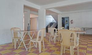 a dining room with tables and chairs and a staircase at Itsy By Treebo - AY Plus Hotels in Kharadi