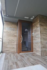 vestíbulo con puerta de madera en un edificio en La Piana Hotel, en Tito
