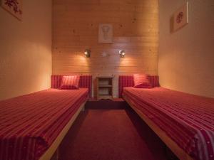 ヴァルモレルにあるAppartement Valmorel, 2 pièces, 5 personnes - FR-1-356-200の赤いシーツが備わるドミトリールームのベッド2台