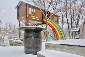 uma casa na árvore num parque com um arco-íris em Center of ecotourism Berkhino em Lukhovitsy