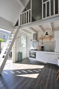 a kitchen with white cabinets and a staircase at Vakantiehuisje Lijsterhofstraat 13 - Baddomburg in Domburg