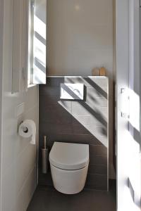 a bathroom with a white toilet in a room at Vakantiehuisje Lijsterhofstraat 13 - Baddomburg in Domburg