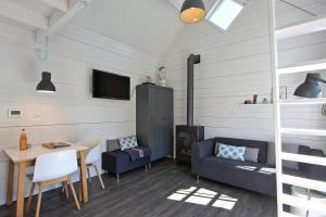 a living room with a couch and a table at Vakantiehuisje Lijsterhofstraat 13 - Baddomburg in Domburg