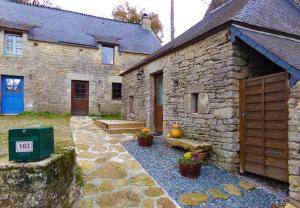 una casa de piedra con una puerta azul y algunas plantas en Gîte Youna - Nature et charme breton entre Lizio et Josselin, en Lizio