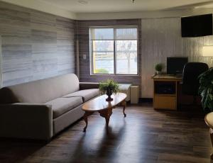 a living room with a couch and a table at Comfort Inn Boston Milford in Milford