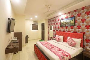 a bedroom with a large bed with a red headboard at Kelvish Hotel-Delhi Airport in New Delhi