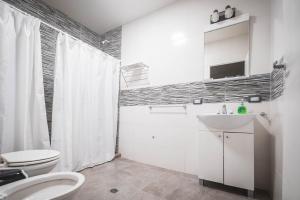 a white bathroom with a toilet and a sink at HYGGE FORMOSA in Formosa