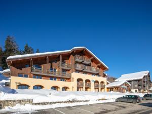 a building in the snow with a parking lot at Vacanc&eacute;ole - R&eacute;sidence Le Beauregard in La L&eacute;ch&egrave;re