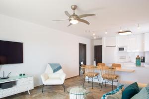een woonkamer met een bank en een tafel met stoelen bij Plata alta - Villa Arosa in Playa Blanca