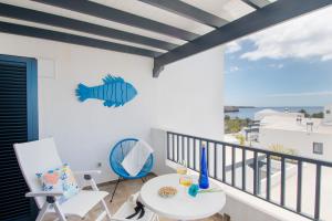 een kamer met een balkon met een tafel en stoelen bij Plata alta - Villa Arosa in Playa Blanca