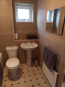 a bathroom with a toilet and a sink at Comfortable Billericay Home in Billericay