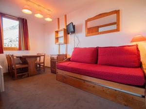 een slaapkamer met een rode bank en een tafel bij Appartement Valmorel, 1 pièce, 4 personnes - FR-1-356-180 in Valmorel