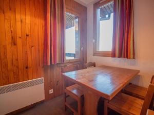 comedor con mesa de madera y 2 ventanas en Appartement Valmorel, 1 pièce, 4 personnes - FR-1-356-180, en Valmorel
