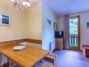 a living room with a wooden table and a television at Appartement Valmorel, 2 pièces, 5 personnes - FR-1-356-201 in Valmorel