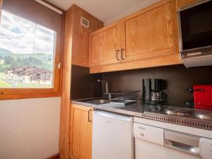 a small kitchen with wooden cabinets and a window at Appartement Valmorel, 2 pièces, 5 personnes - FR-1-356-290 in Valmorel