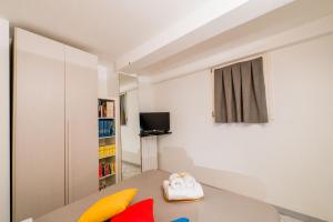 een kleine kamer met een bed en een boekenplank bij FEEL - Minimal House - Bergamo Centro in Bergamo