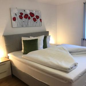 - une chambre avec 2 lits avec des fleurs rouges sur le mur dans l'établissement Gästehaus Hosp, à Reutte