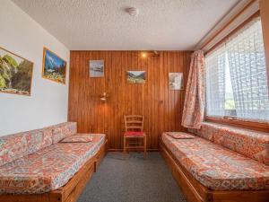 a room with two beds and a chair in it at Appartement Valmorel, 1 pièce, 4 personnes - FR-1-356-291 in Valmorel