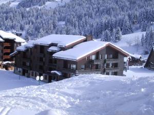 a building covered in snow with snow covered roofs at Appartement Valmorel, 1 pièce, 4 personnes - FR-1-356-284 in Valmorel