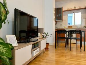 sala de estar con TV de pantalla plana grande en Picassia Home Malaga Center, en Málaga
