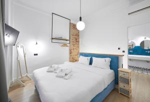 een slaapkamer met een groot bed en handdoeken bij The Maroon Bottle Luxury Suites in Thessaloniki