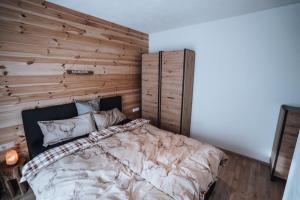 a bedroom with a large bed with a wooden wall at Haus Bergzauber in Ramsau am Dachstein