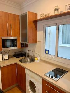 a kitchen with a sink and a washing machine at Picassia Home Malaga Center in Málaga