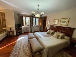 a bedroom with two beds and a chandelier at Casa rural en entorno privilegiado 