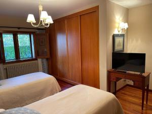 ein Hotelzimmer mit zwei Betten und einem Fernseher in der Unterkunft Casa rural en entorno privilegiado in Valongo