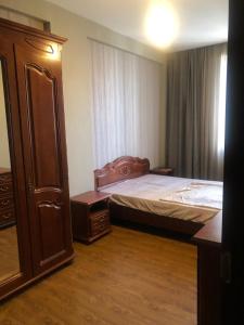 a small bedroom with a bed and a dresser at Dona Palace Apartments in Tbilisi City