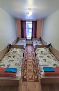 a room with four beds in it with a window at Хостел"Компас" in Kungur