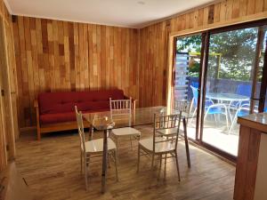 Un comedor con una mesa de cristal y sillas. en Departamentos Del Lago, en Licán Ray 8 fotos más