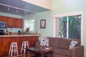 a living room with a couch and a kitchen at Hale Honu home in Keaau