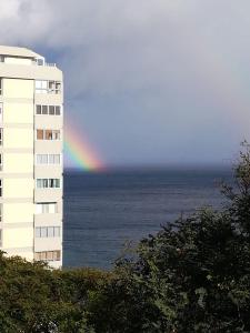 a rainbow over the ocean next to a building at Tamariz Flat in Santa Cruz