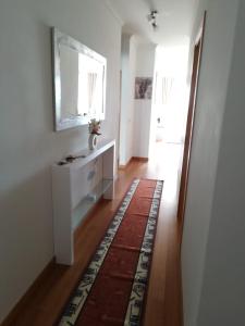 uma sala de estar com uma cómoda branca e um espelho em Tamariz Flat em Santa Cruz