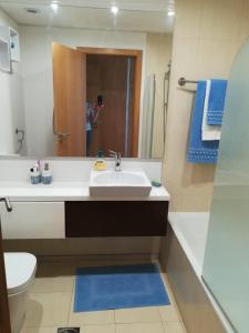 a bathroom with a sink and a toilet and a mirror at Tamariz Flat in Santa Cruz