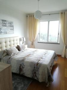 een slaapkamer met een groot bed en een groot raam bij Tamariz Flat in Santa Cruz