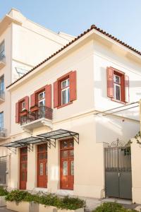 una casa bianca con porte e finestre rosse di Ether Loft Suites ad Atene