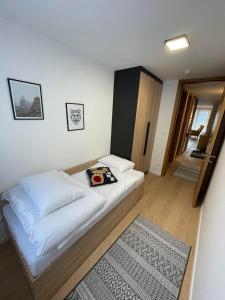 Un dormitorio con una cama y una alfombra. en Olimpijska kuca 202, en Jahorina