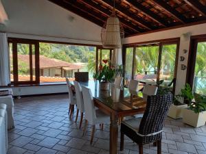 una sala da pranzo con tavolo e sedie di CASA MARAVILHOSA à BEIRA MAR EM ANGRA DOS REIS ad Angra dos Reis
