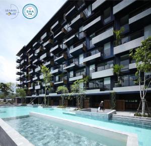 a building with a swimming pool in front of it at Seamira House Huahin - SHA in Hua Hin