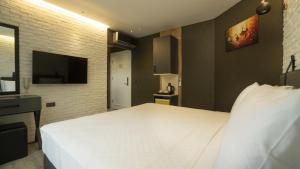 a bedroom with a large white bed and a tv at Estera Hotel Silent in Antalya