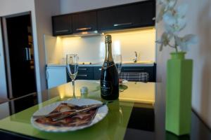 a bottle of wine and a plate of food on a table at Divčibarski Vajati in Divčibare